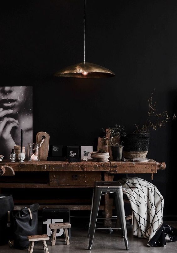 Industrial style reclaimed wood table, barstool in matte black room. 